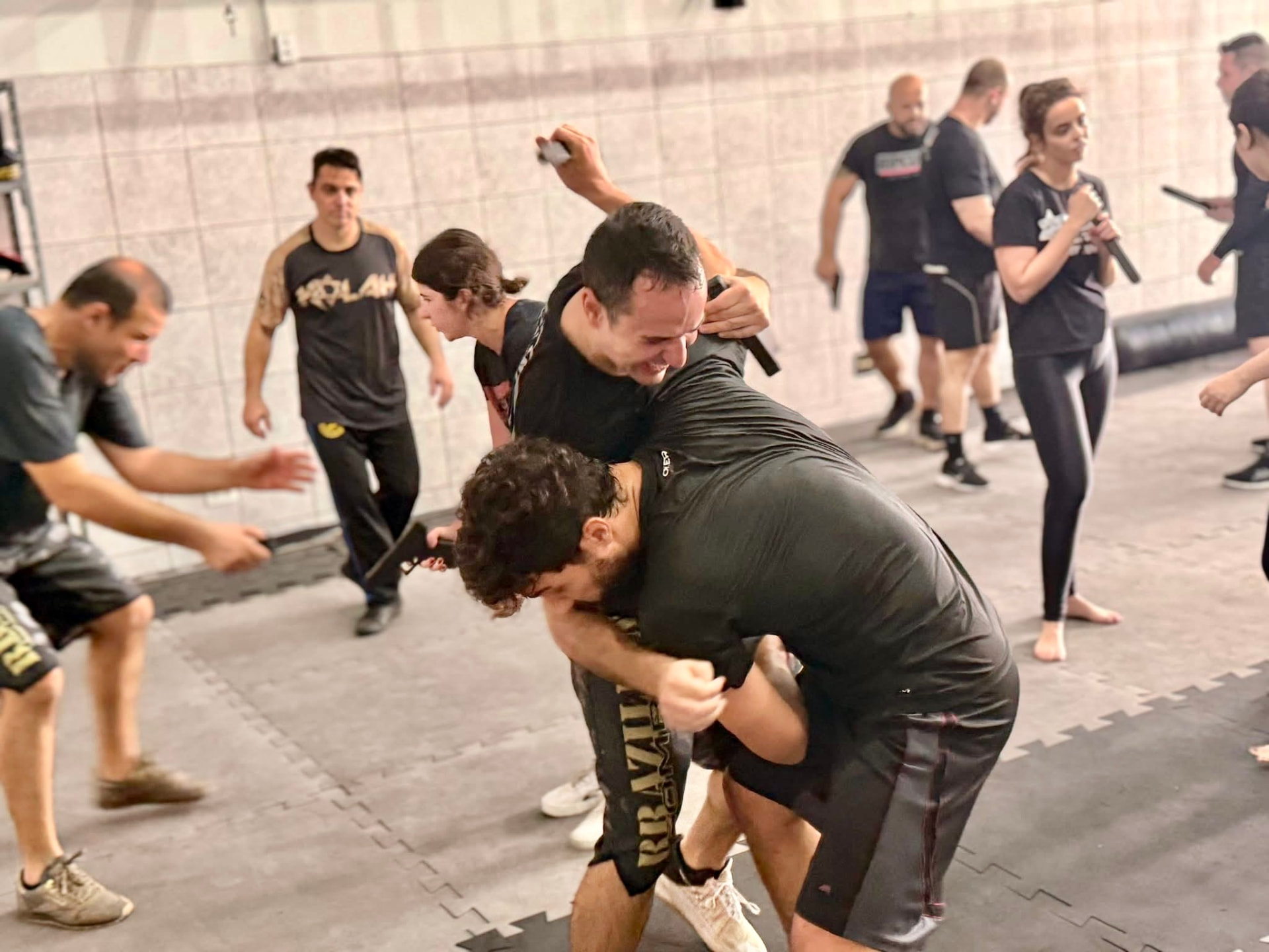 Multiple Kalah participants practicing resistance training, with two men working in the foreground